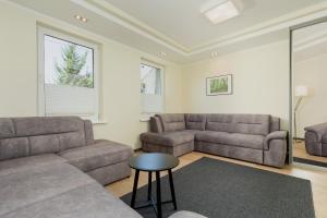 a living room with two couches and a table at Family Holiday House VIKING - Garden, Playground & Grill by Noclegi Renters in Kołczewo