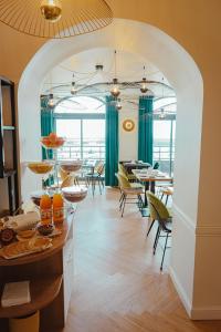 a restaurant with an archway with tables and chairs at Grand Hôtel de Bretagne in Le Palais