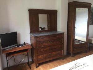ein Schlafzimmer mit Kommode und Schreibtisch mit Fernseher in der Unterkunft Da Boni & Luci in Novate Mezzola