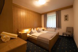 a hotel room with a bed and a desk and a window at Hotel Maibad in Vipiteno +44 photos