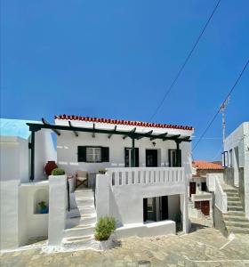 a white house with stairs in front of it at Cycladic Maisonette (Dryopida, Kythnos) in Kithnos