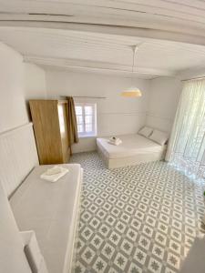 a white room with a bed and a window at Cycladic Maisonette (Dryopida, Kythnos) in Kithnos