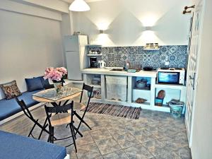 cocina y sala de estar con mesa y sillas en Enjoy Cyclades studios & suites en Kíthnos