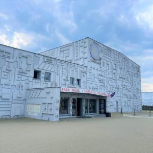 un gran edificio blanco con un cartel en la parte delantera en Noclegi JuraPark Krasiejów, en Krasiejów