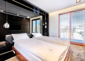 - une chambre avec un grand lit et une grande fenêtre dans l'établissement Imperial Apartments - Aquarius VI, à Sopot