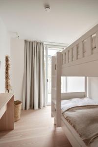 a white bedroom with a bunk bed and a window at Inselhouse in Norderney
