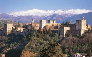 una ciudad en la cima de una colina con montañas cubiertas de nieve en Pensión Eurosol en Granada