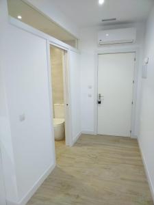 奥苏纳CASTRO Suites Osuna的空空房间,设有白色的墙壁和木地板