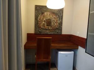 a desk in a room with a painting on the wall at Pousada do Gunga in Barra de São Miguel