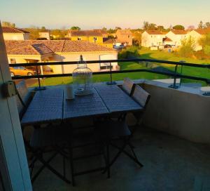 a bird cage sitting on a table on a balcony at Au levant de Marie in Gaillac