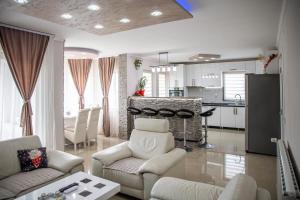 a living room with white furniture and a kitchen at Apartmani Đorđević in Soko Banja