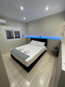 ein Schlafzimmer mit einem großen weißen Bett mit blauen Akzenten in der Unterkunft Luxury 3 bedroom apartment in Kiato center in Kiato