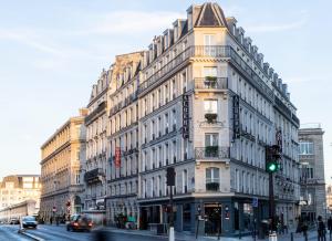 a tall building on a city street with a green traffic light at H&ocirc;tel Albert 1er Paris Lafayette in Paris