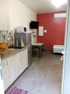 uma cozinha com um balcão e uma mesa num quarto em Studio avec terrasse et wifi a Canton des Abymes 3 a 2 km de la plage em Le Gosier