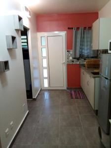uma cozinha com paredes vermelhas e uma porta branca em Studio avec terrasse et wifi a Canton des Abymes 3 a 2 km de la plage em Le Gosier