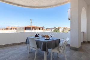 a dining table and chairs on a balcony with a view at Al Castello - Etna e Mare in Agnone Bagni