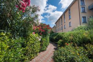 a brick path in front of a building with flowers at Hotel Villa Paradiso in Passignano sul Trasimeno