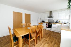 uma cozinha e sala de jantar com uma mesa de madeira e cadeiras em Town House D em Dunston