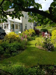 een tuin met kleurrijke bloemen en een huis bij Eagles View Private Cottage - Betws Y Coed in Betws-y-coed