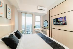 una camera con un grande letto e una TV a parete di Kingston Apartment - Anderson Studio A25 a Lontar