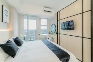 una camera da letto con un grande letto bianco e una grande finestra di Kingston Apartment - Anderson Studio A25 a Lontar