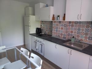 a kitchen with white cabinets and a sink at Monte Sueve in Arriondas