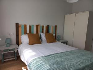 a bedroom with a large white bed and two tables at Monte Sueve in Arriondas