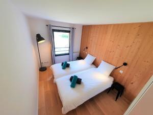 two beds in a room with two green pillows on them at La Cordee - Charmant Appartement - 4 personnes in Chamonix-Mont-Blanc