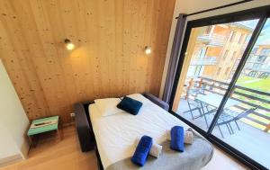 a bedroom with a bed with two blue pillows on it at La Cordee - Charmant Appartement - 4 personnes in Chamonix-Mont-Blanc