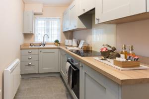 une cuisine avec des placards blancs et un comptoir dans l'établissement Bridge Hideaway, à Llangollen