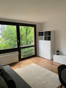 a living room with a large window and a kitchen at Suite minimalist 50m2 in Brussels