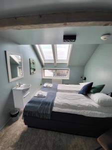 a bedroom with a large bed and a sink at Å Hotell - by Classic Norway Hotels in Å