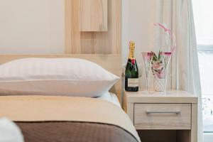 a bottle of wine on a table next to a bed at Willa Lala in Szczawnica