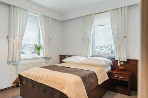 a bedroom with a bed and two windows at Willa Lala in Szczawnica +88 photos