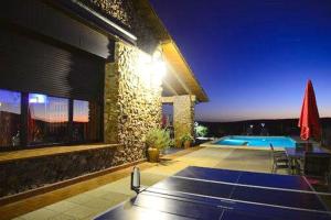 una casa con piscina por la noche en 4 bedrooms villa with private pool enclosed garden and wifi at Fernan Caballero en Fernancaballero