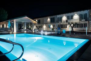 a swimming pool at night with a hotel in the background at Dimora San Carlo in Roddi