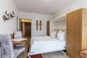 une chambre d'hôtel avec un lit et une chaise dans l'établissement Ferienwohnung Hillgruber, à Oberstdorf