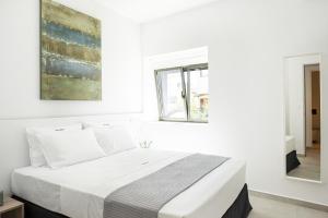 Habitación blanca con cama y ventana en Cozy Corner Luxury Apartments en La Canea