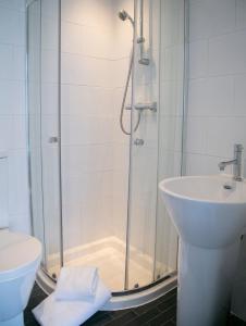 a bathroom with a shower and a toilet and a sink at Harlow Apartment 3 in Harrogate