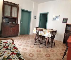 Habitación con mesa, sillas y cama en Casa Vacanze Else, en Lazzaro