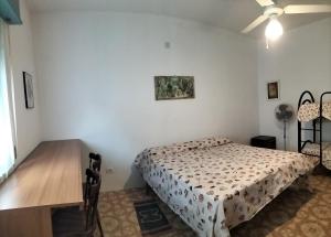 sypialnia z łóżkiem, biurkiem i wentylatorem sufitowym w obiekcie Casa Vacanze Else w mieście Lazzaro +2 zdjęcia