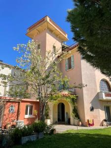 una grande casa con un albero di fronte di Domaine du Petit Tournebelle a Gruissan