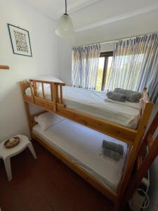 sypialnia z 2 łóżkami piętrowymi i oknem w obiekcie Stunning Beachfront Apartment Strátos w mieście Nerántza