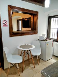 a kitchen with a table and two chairs and a mirror at Historic Center Apartment in Braşov