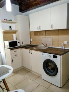 a kitchen with a washing machine and a microwave at Historic Center Apartment in Braşov