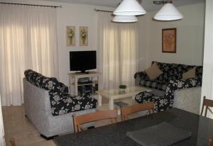 ein Wohnzimmer mit 2 Sofas und einem TV in der Unterkunft Luxury villa in Islantilla