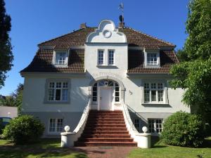 una gran casa blanca con escaleras que conducen a ella en Villa Friedericia - Whg1, en Wyk auf Föhr