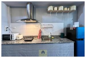 a kitchen counter with a sink and a microwave at Hooman Hostel in Chiang Mai
