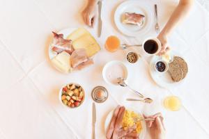 een tafel met borden met eten en drinken bij Hotel Montana in Vason