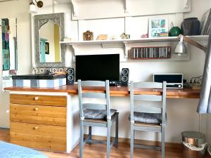 a kitchen with a desk with a computer and two chairs at City room in Alkmaar +21 photos